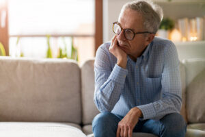 older man pensive on couch