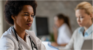 doctor looking at screen with other doctors in background