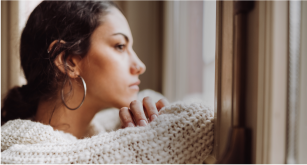 woman leaning against window looking out