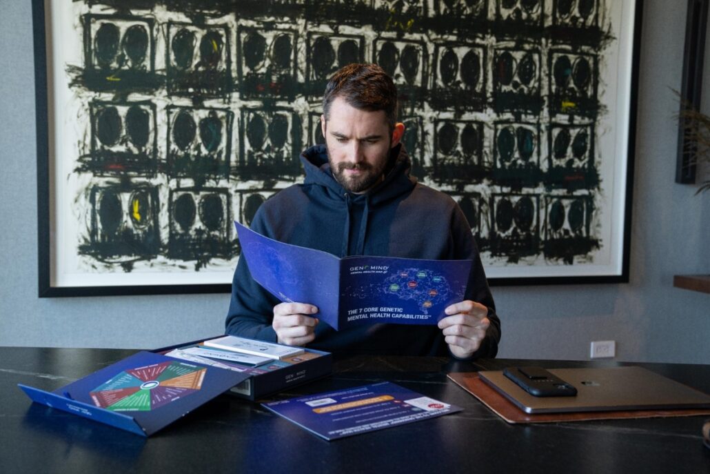 Kevin Love NBA player holding brochure in front of open box Genomind® Mental Health Map™