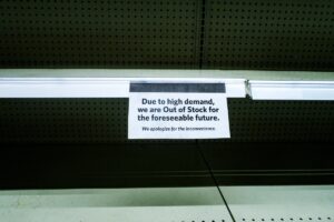 out of stock sign on empty shelf