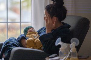 woman holding newborn baby illustrating maternal mental health