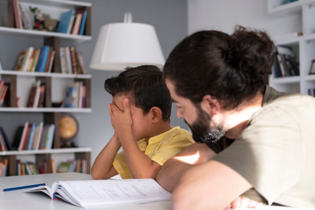 father reading book to son who is covering eyes