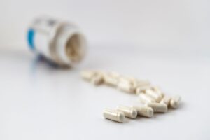 white pill capsules spilling out of bottle