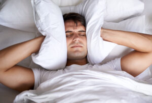 man lying in bed feeling anxiety so bad you can't sleep