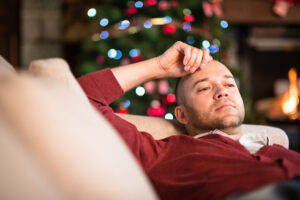 man lying on back with hand on forehead