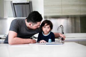 father consoling son in kitchen trying how to improve focus in kids