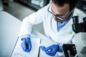 lab technician making notes on pharmacogenomics sample