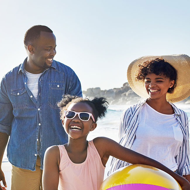 Smiling family walks down the beach